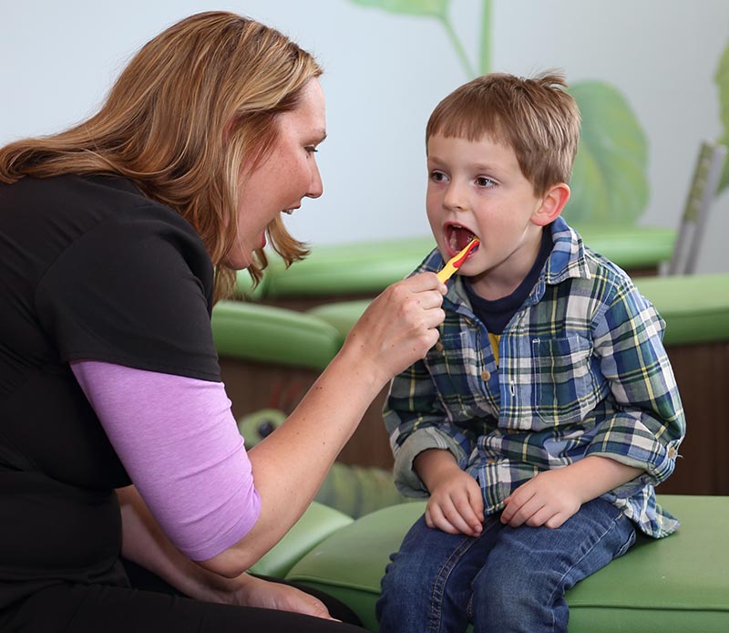 dentist brushing young boys teeth
