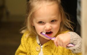 little girl brushing her teeth